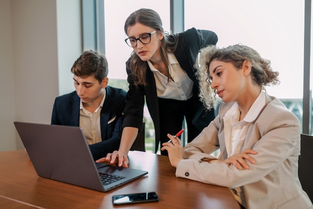 three property managers looking over a report on a laptop)